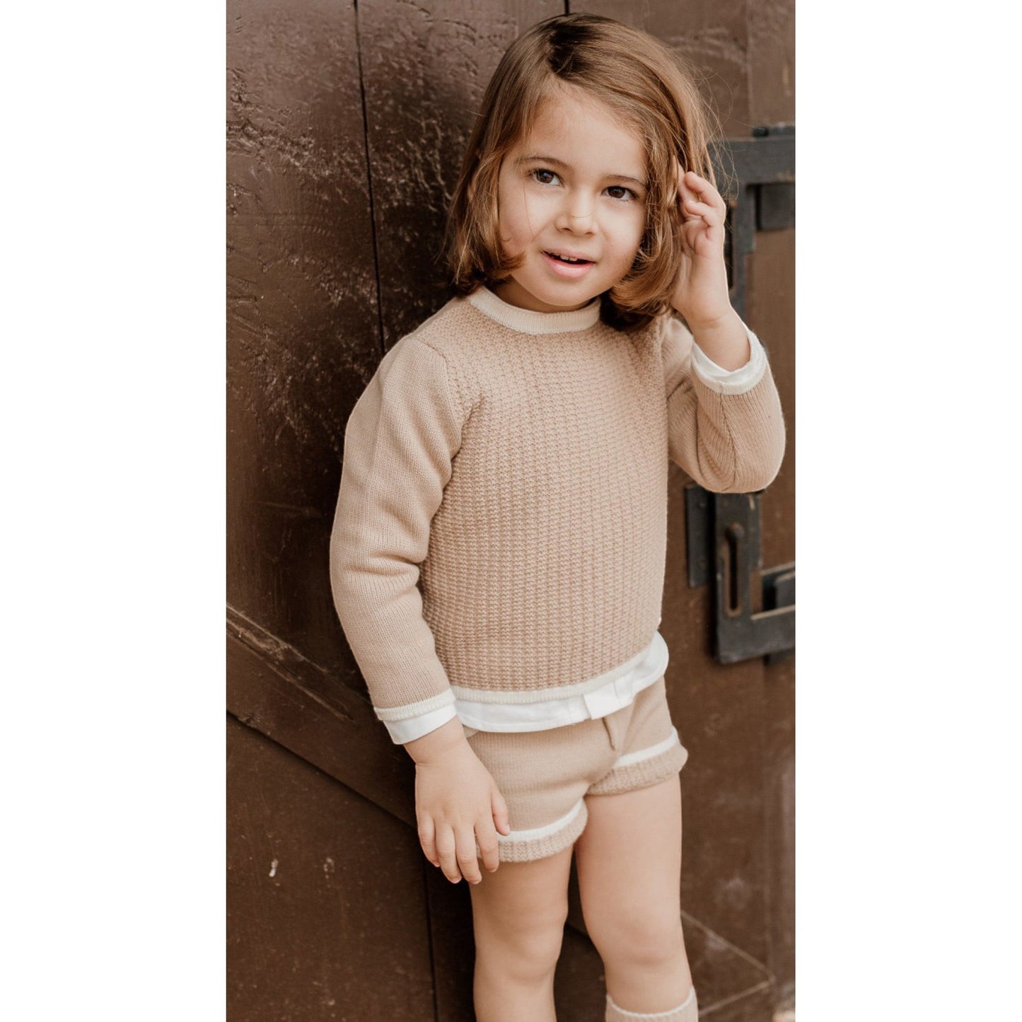 Boys neutral outfit featuring camel coloured knitted shorts and jumper with cream piping by Rahigo 